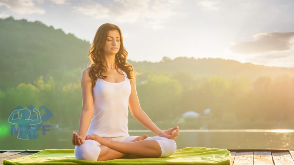 Woman Using Meditation Reverse Aging next to a calm lake during sunset.