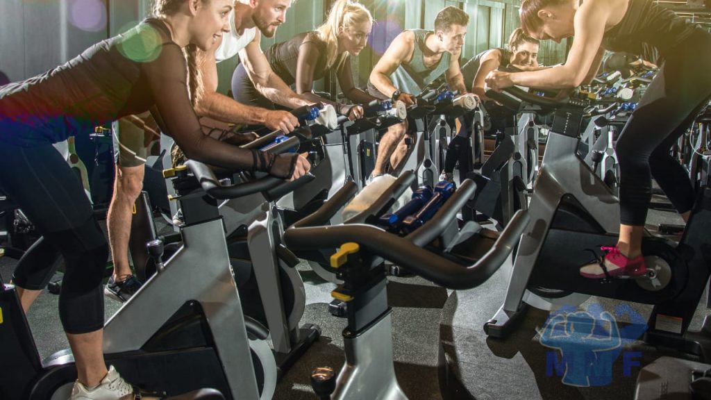 Group performing high-intensity interval training in a cycling spin class.