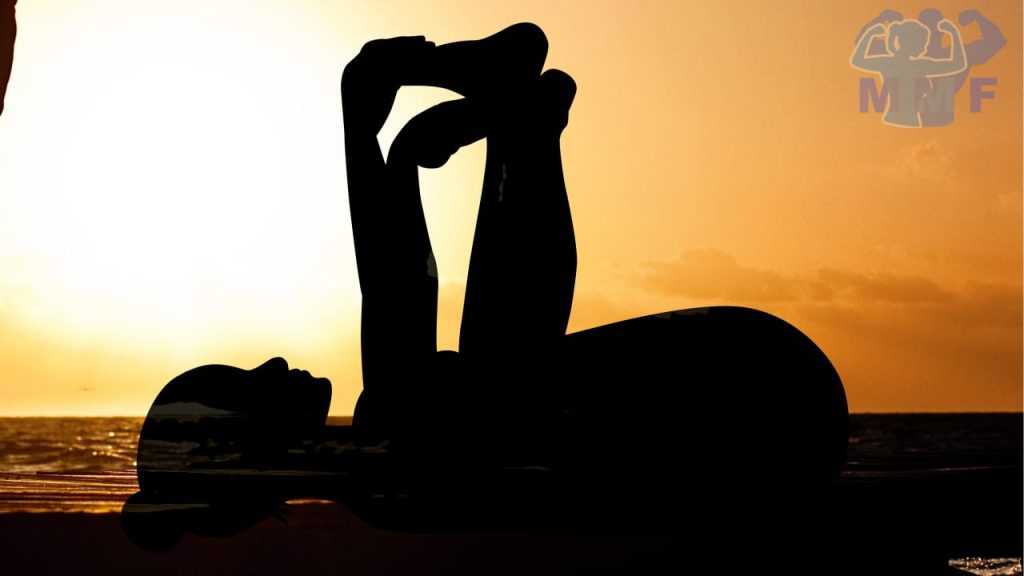 Woman silhouette performing happy baby at sunset doing Yin Yoga Benefits of Restorative Yoga.