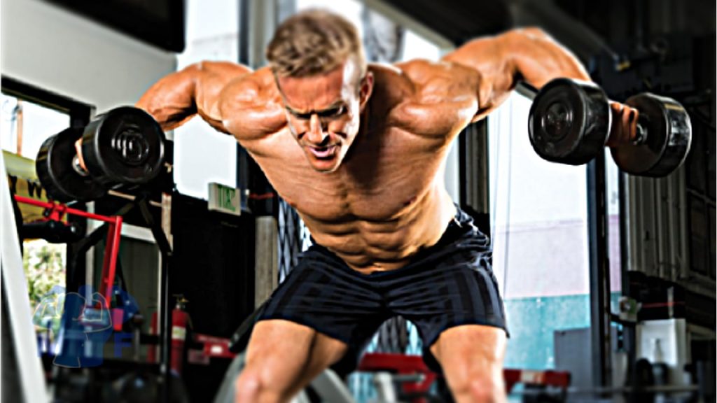Muscular man without a shirt performing dumbbell rear lateral raises in a gym.